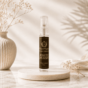 White Desert Eau de Parfum inspired by White OUD in a 10ml travel-size spray bottle by RocheHayatt Luxury Perfumes displayed on a luxury beige marble podium.