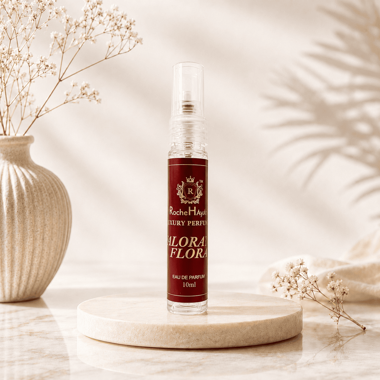 Valorant Flora inspired by Gucci Flora perfume in a 10ml travel-size spray bottle displayed on a beige marble podium with soft floral décor and elegant natural lighting.